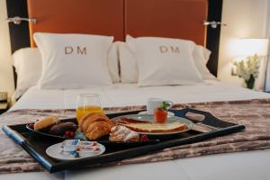 a tray of breakfast food on a bed at Gran Hotel Don Manuel in Cáceres