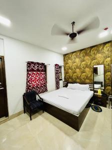 a bedroom with a bed and a ceiling fan at Hotel Airlines in Kolkata