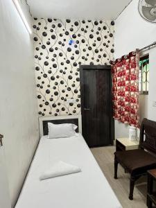 a bedroom with a bed and a wall with a flower pattern at Hotel Airlines in Kolkata