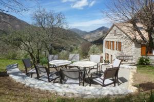 a group of chairs and a table in front of a house at Entre Terre et Ciel in Rémuzat