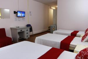 a room with three beds and a desk and a tv at QUANG SAIGON Hotel- 40-7 Bùi Viện-Walking street in Ho Chi Minh City