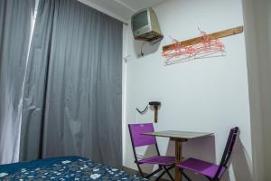 una camera da letto con un tavolo e due sedie viola di GarçaView a Vila Franca do Campo