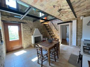 jadalnia z drewnianym stołem i ceglaną ścianą w obiekcie agriturismo borgo del ginepro w mieście Castiglione Messer Raimondo