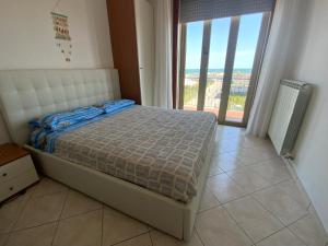 um quarto com uma cama e uma grande janela em Bella Vista apartment em Chioggia