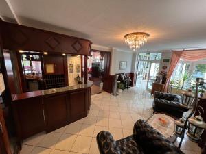 a lobby with a bar with leather chairs at Hotel Poseidon in Kühlungsborn