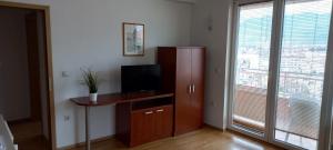 a living room with a tv and a desk and a window at Boris & Matej Apartments in Ohrid