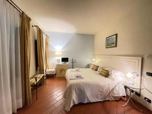 a bedroom with a white bed in a room at IL COLOMBAIO Winery in Monteriggioni +210 photos