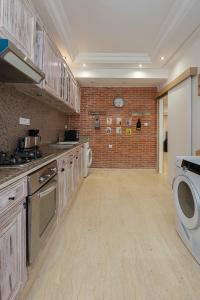 a kitchen with wooden cabinets and a brick wall at Luxury two bedrooms apartment - Best Location in Rabat