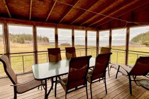 a screened in porch with a table and chairs at Seaside Cottage in Saint George