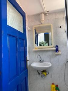 a bathroom with a blue door and a sink at The house of grandma Zinios in Ioulida