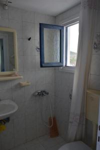 a bathroom with a toilet and a window and a shower at The house of grandma Zinios in Ioulida