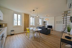 uma cozinha e sala de estar com uma mesa e um sofá em duplex appartement 70m2 atypique au cœur du Mans em Le Mans