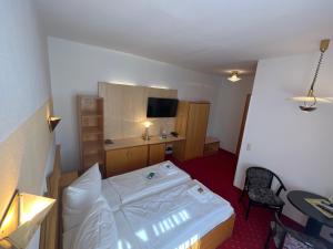 a small room with a bed and a desk at Hotel Poseidon in Kühlungsborn