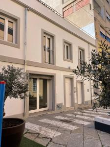 a large white building with windows and a courtyard at Matty's in Olbia