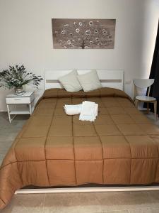 1 dormitorio con 1 cama grande y edredón marrón en Matty's, en Olbia