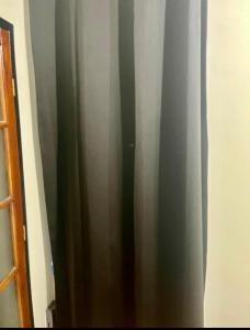 una cortina gris en una habitación al lado de una puerta en Appartement bien agencé, en Les Lilas