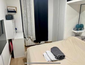 1 dormitorio con 1 cama con toallas en Appartement bien agencé, en Les Lilas