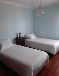 2 Betten in einem Zimmer mit weißer Bettwäsche in der Unterkunft Parfum de la Mer in Sines