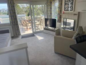 a living room with a couch and a tv and a balcony at B23 in Goodrington