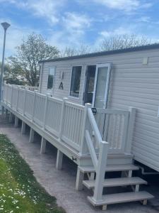 a white mobile home with a porch and stairs at B23 in Goodrington