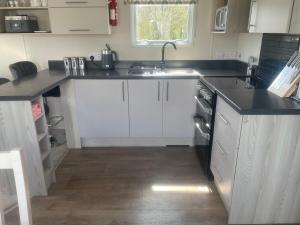 a kitchen with white cabinets and a sink at B23 in Goodrington