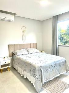 伊列乌斯Apê Ilha Graciosa, Praia dos Milionários Ilhéus-Ba的一间带床和窗户的白色卧室 更多55张照片