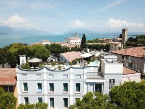 a view of a white building in a city at Hotel Enrichetta in Desenzano del Garda