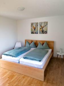 a bedroom with a large wooden bed with two pillows at Ferienhaus Chiara, Südharz, Harztor in Ilfeld