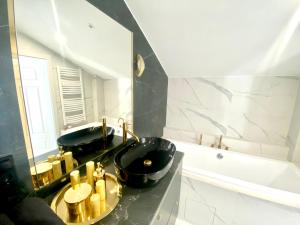 ein Badezimmer mit zwei schwarzen Waschbecken und einer Badewanne in der Unterkunft Apartament Sanok-z widokiem na rynek i tarasem in Sanok