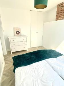 a bedroom with a bed with a green blanket on it at Apartament Sanok-z widokiem na rynek i tarasem in Sanok