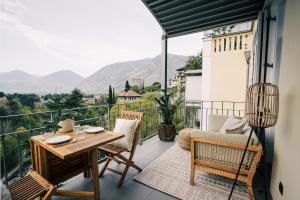 a balcony with a table and chairs and a view at meralino boutique apartment in Merano
