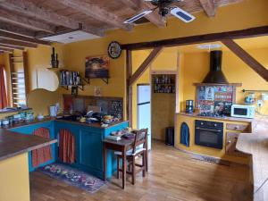 una cocina con una isla azul con una mesa. en Le Moulin d'Errol, en Saint-Jean-dʼAngély