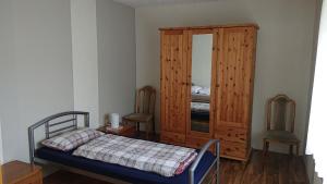 1 dormitorio con 1 cama y armario de madera en Ferienwohnung Linde - Marburg Biedenkopf mit 5 Zimmer und Balkon, en Frechenhausen