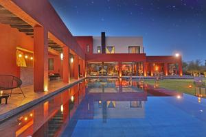 a large house with a swimming pool at night at DAR NOUJOUM in Marrakesh