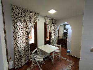 Una cocina y un comedor con mesa y sillas. en Apartamento Santa Inés, en Granada