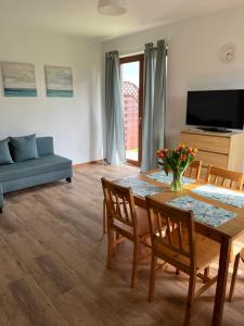 a living room with a table and chairs and a couch at Apartamenty Łeba in Łeba