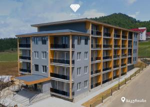 バクリアニにあるBakuriani Crystal Loft 412の丘を背景にしたビーチ沿いのアパート