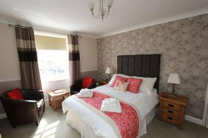 una camera con un grande letto e una sedia di The Warwick a Weymouth