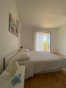Un dormitorio blanco con una cama grande y una ventana en Room for Two en Baška Voda