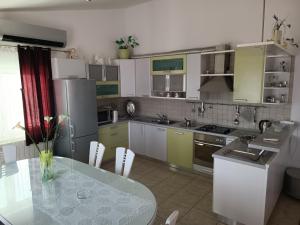 una cocina con mesa y una cocina con armarios amarillos y verdes en Apartment Jagoda, en Primošten
