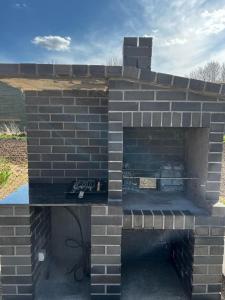 a brick oven in a yard with a brick wall at Black Horse in Pasłęk
