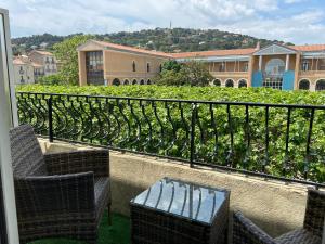 balcón con sillas, mesa y viñedo en Hotel Regina en Sète