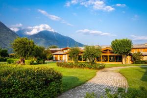 a house with a garden and mountains in the background at Agriturismo La Fiorida in Mantello
