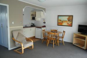 a kitchen and dining room with a table and chairs at Loredo Motel in Kaitaia