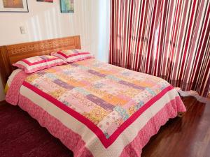 a bedroom with a bed with a colorful quilt at Apartamento La Cusqueñita in Cusco