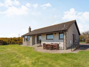 a house with a table and chairs in a yard at Craigievar in Cruden Bay