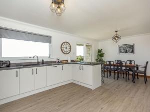 a kitchen with white cabinets and a dining room at Craigievar in Cruden Bay