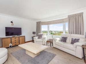 a living room with white furniture and a large window at Craigievar in Cruden Bay