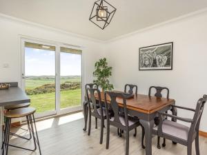 una sala da pranzo con tavolo, sedie e finestra di Craigievar a Cruden Bay