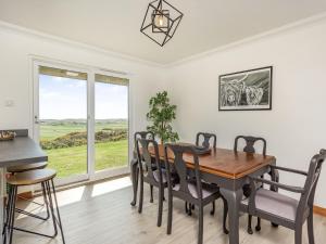a dining room with a table and chairs and a window at Craigievar in Cruden Bay